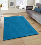 Luxury artisan wool rug in teal with subtle border frame